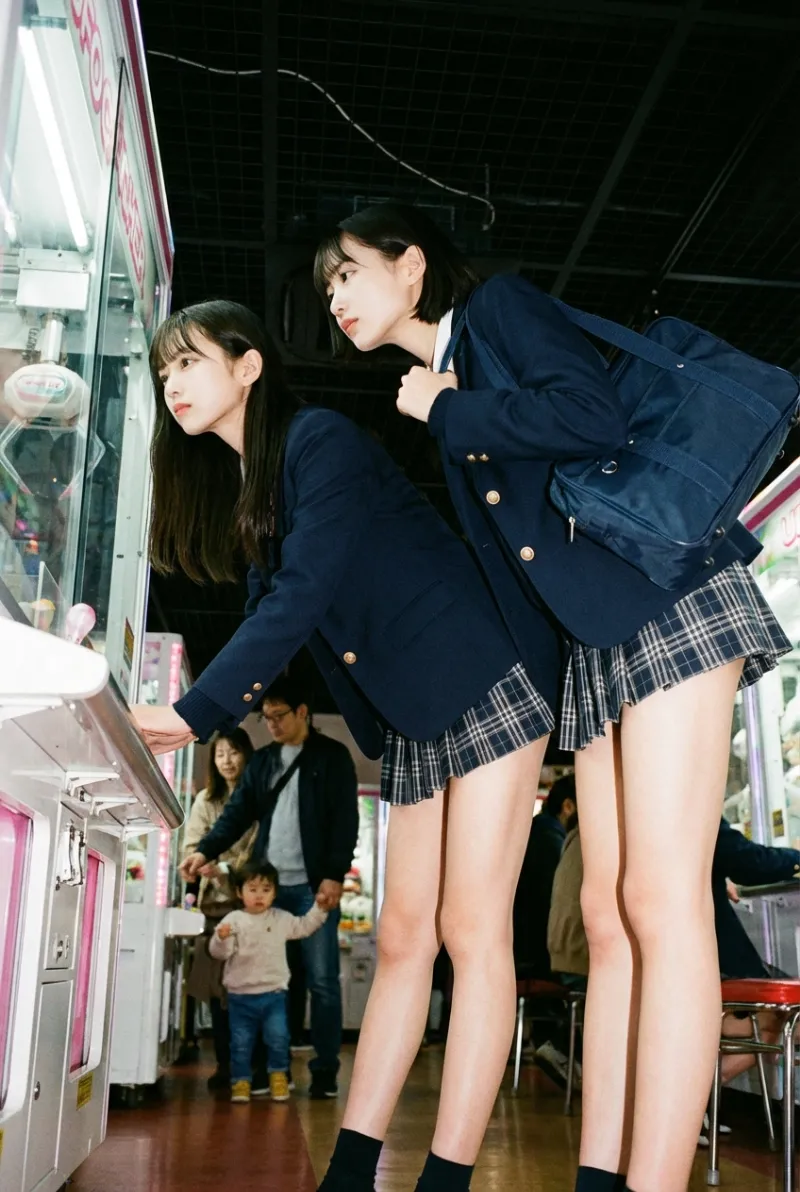ゲームセンターでUFOキャッチャーをするJK2人（AI画像生成）