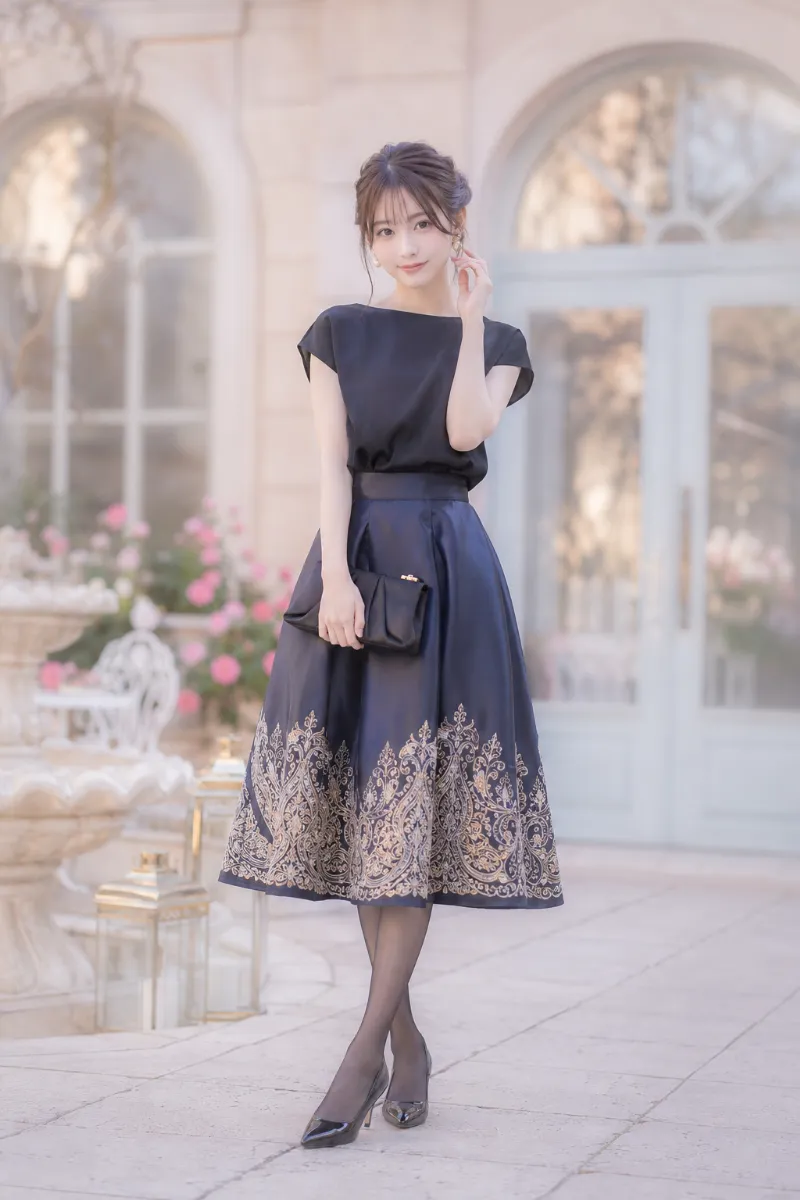 実写AI美女版｜ペイズリー刺繍入りのディープネイビーAラインスカートに黒ブラウスとクラッチバッグを合わせたオリエンタルコーデ