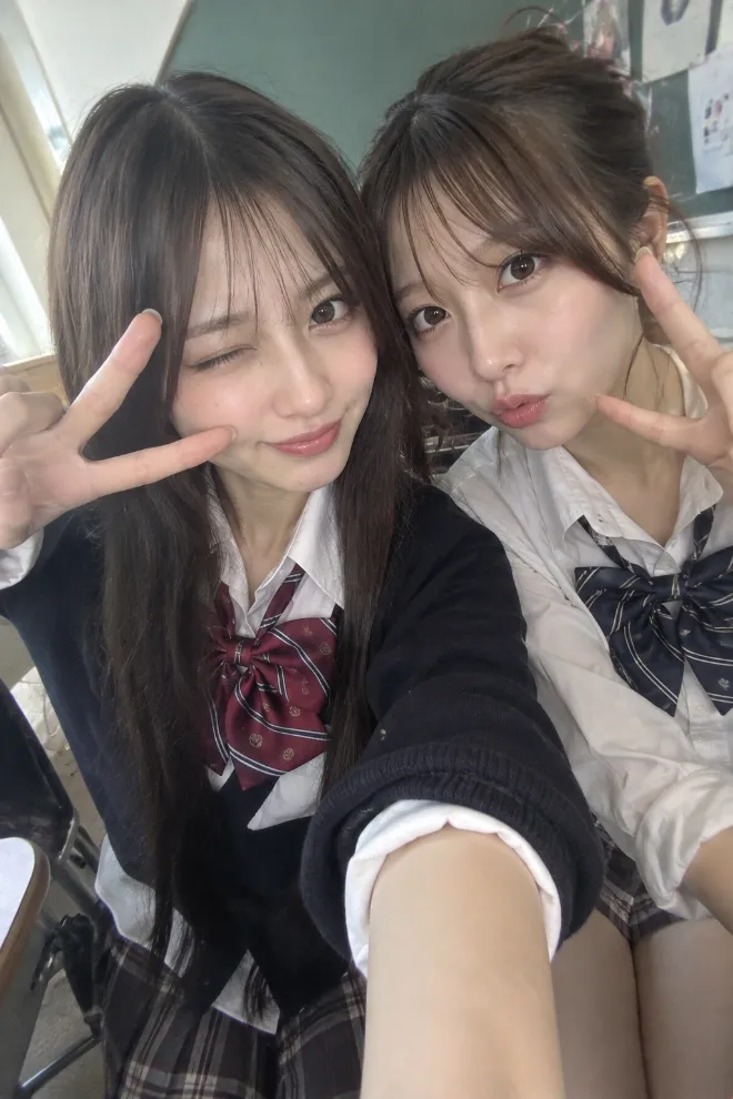 スマホのフロントカメラで撮影した自撮り風写真。制服姿の20歳の日本人女性が友人とセルフィーを撮っている。