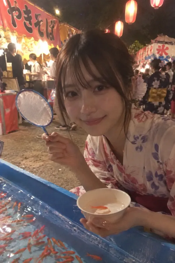 夜の夏祭り。提灯と屋台、金魚すくいが並ぶ日本の祭り風景。
