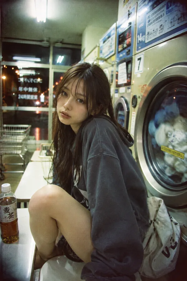 深夜のコインランドリー。蛍光灯の下で洗濯機が並ぶ静かな店内風景。