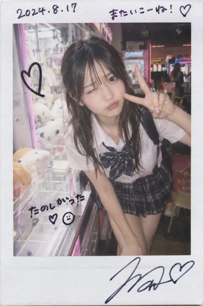 ポラロイド写真風。制服姿の20歳の日本人女性がゲームセンターでポーズをとり、日付と一言コメントが書き込まれている。