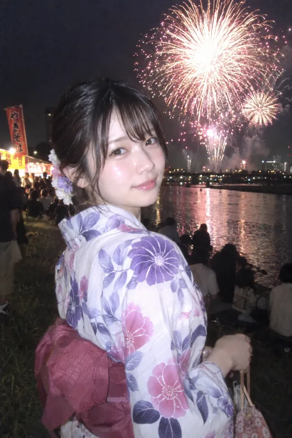 夏の河川敷。夜空に打ち上げ花火が広がる花火大会の写真。