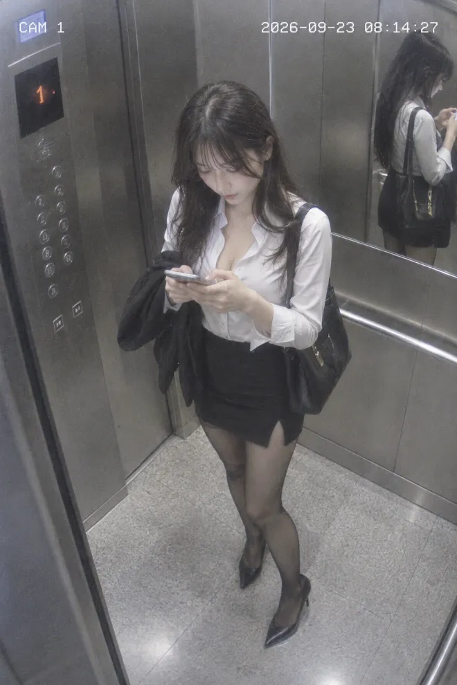 CCTV防犯カメラの静止画風。オフィスサイレン系ファッションの20歳の日本人女性がエレベーター内でスマホを操作している。