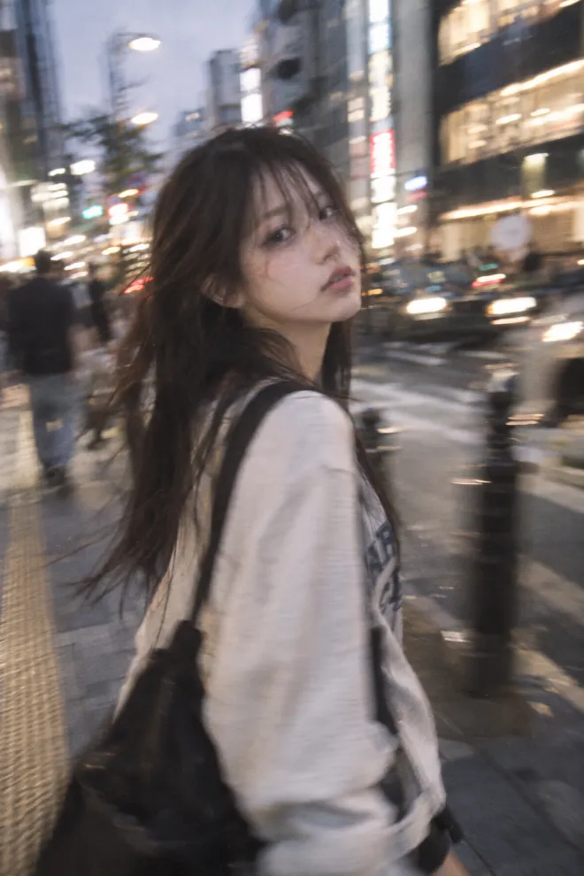 アレ・ブレ・ボケを取り入れた写真。ラフな服装の20歳の日本人女性が都市のストリートを歩いている。