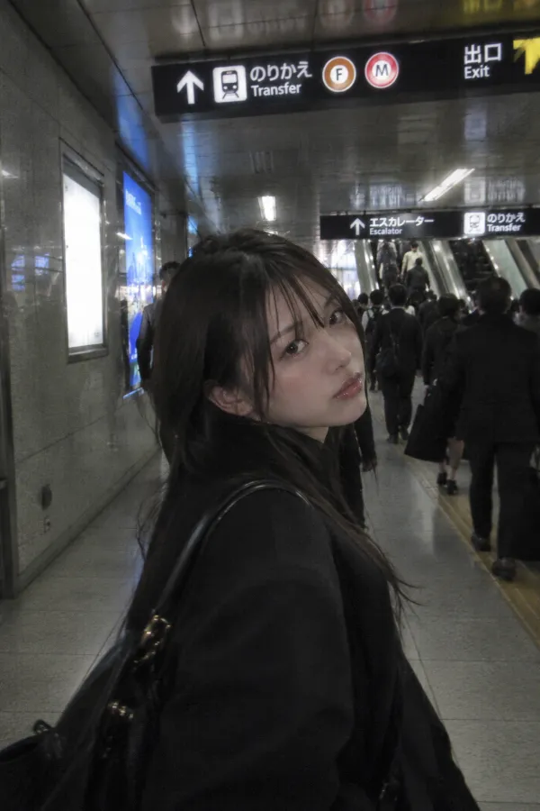 地下駅の長い連絡通路。案内板、エスカレーター、多くの乗客が見える駅構内。