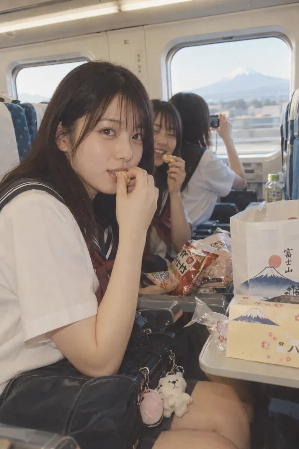 修学旅行の新幹線車内。座席、車窓、お菓子、お土産袋と友人たちが写る写真。